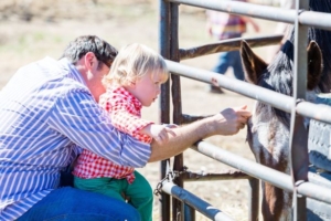 Man and child petting a horse