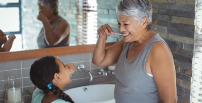 Older woman and child brushing their teeth