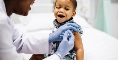Child smiling while getting a vaccine shot