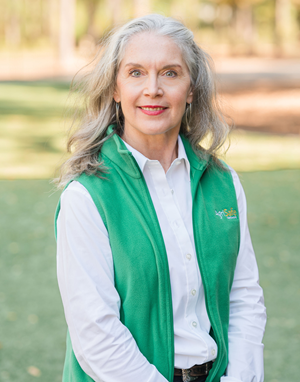 Woman in green vest over white dress shirt
